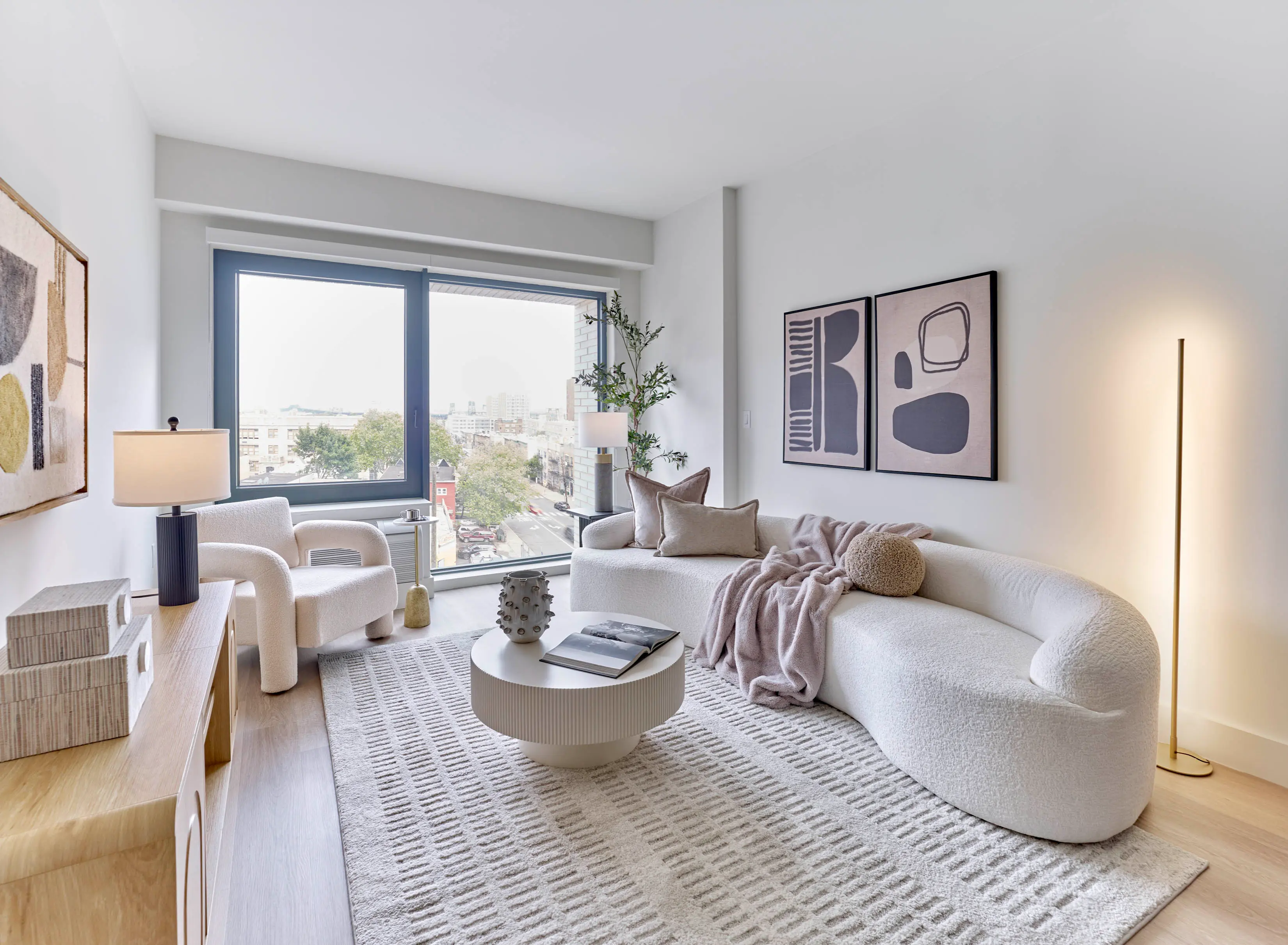 Living room with curved sofa, coffee table, and large window