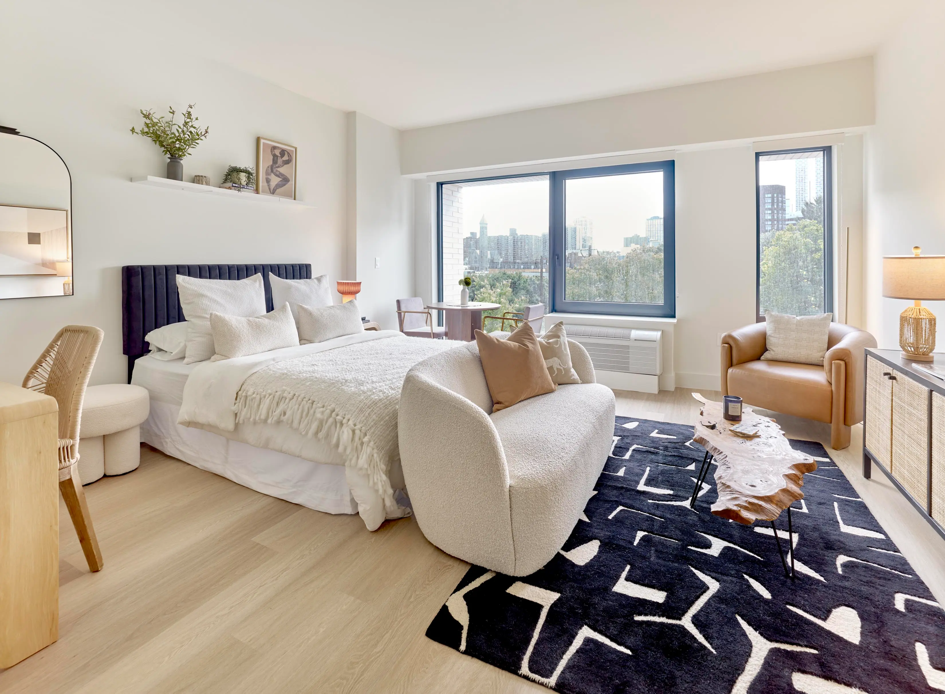 Studio apartment layout featuring bed, sofa, armchair, and windows